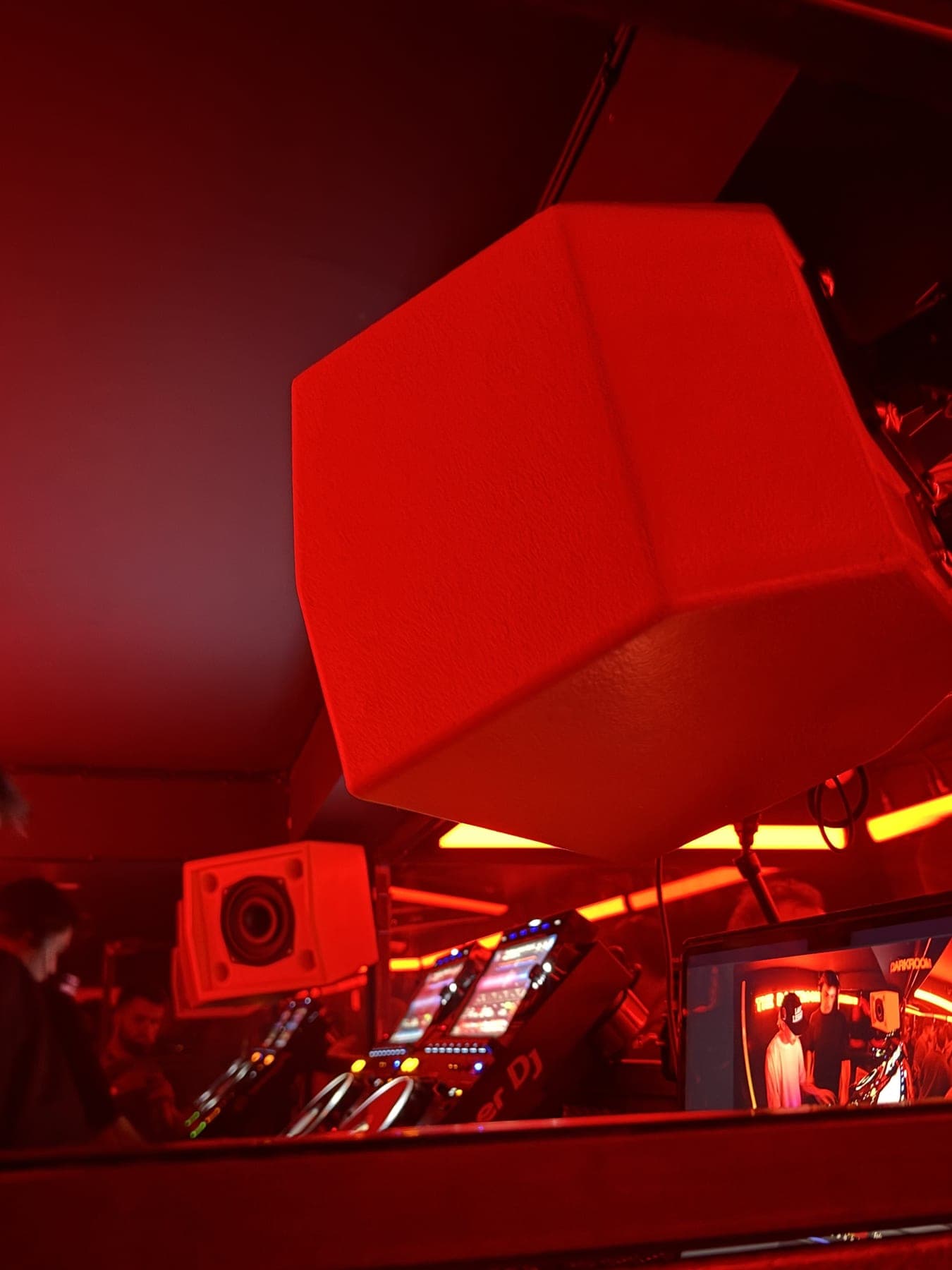 The Darkroom booth monitor, faceted cabinet under red light